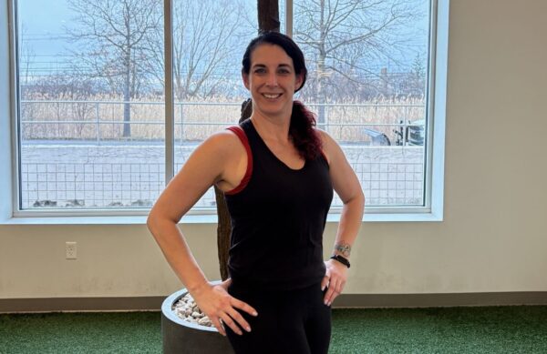 Member of the Month, Catherine, standing and smiling with her hands on her hips. 